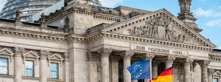 The flags of the European Union and Germany waving in front of the Reichstag