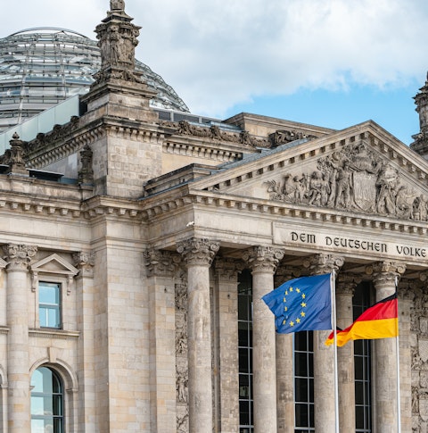 The flags of the European Union and Germany waving in the wind in front of the Reichstag in Berlin
