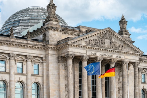 The flags of the European Union and Germany waving in the wind in front of the Reichstag in Berlin