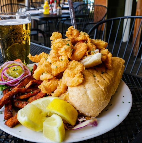 Fried Shrimp PoBoy with Draft Beer served with sweet potato fries and lemon wedges