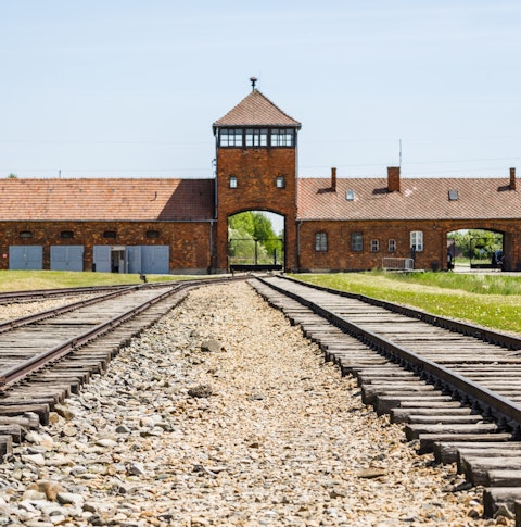 Front view of the main entrance gate of Auschwitz on train tracks