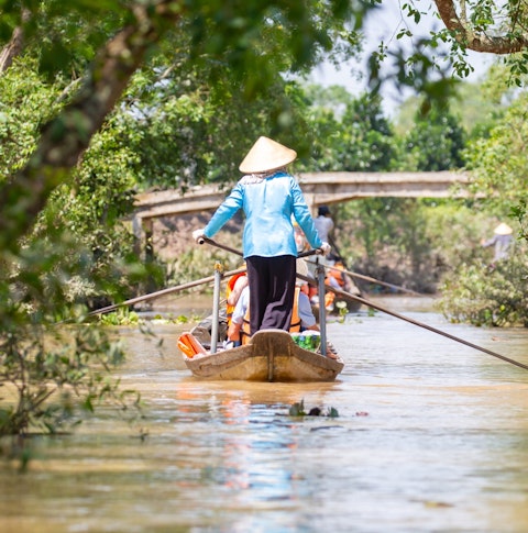Woman driving a boat in the mekong delta in Vietnam