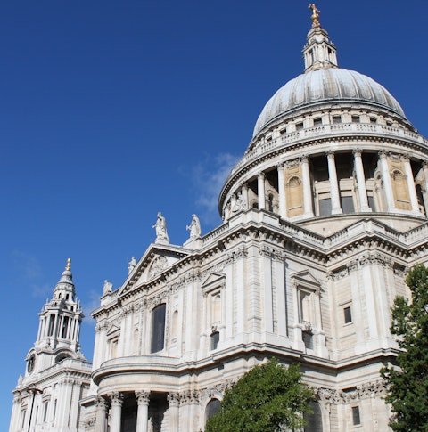 Looking up at St Paul's Cathedral in London on a sunny day with blue skies