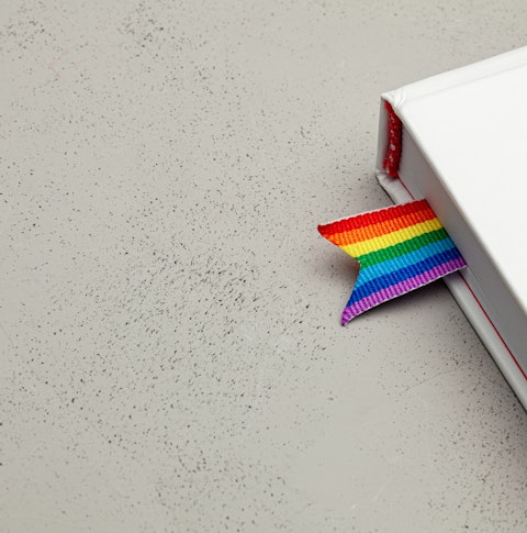 A white book with a rainbow coloured book mark poking out