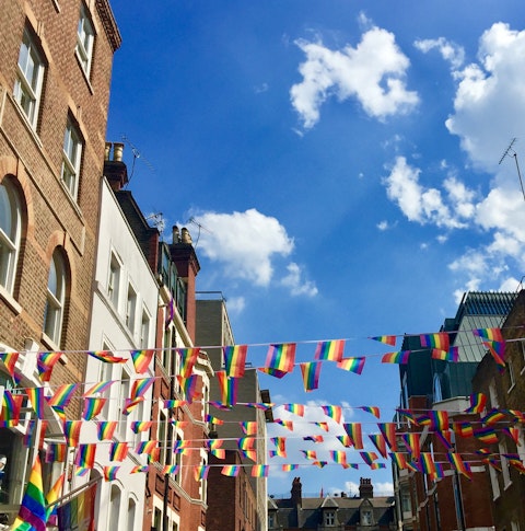 Looking up at Pride flags in a London street on a sunny day