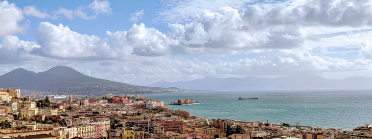 buildings of naples near sear under white clouds and blue sky