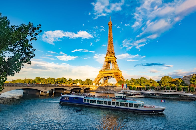Scenic panorama of Eiffel Tower, Seine River, and pont d'lena in Paris, France; with a cruise passing by