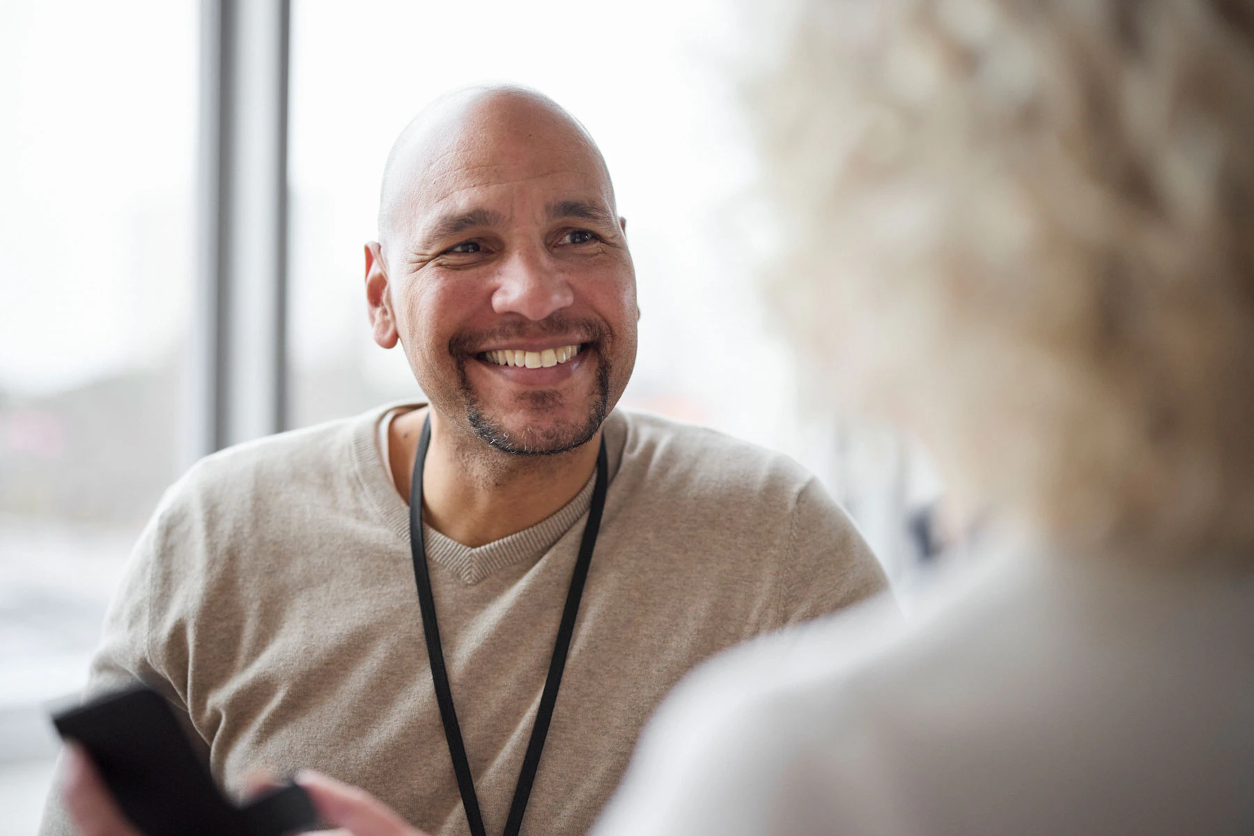 Man smiling at another person