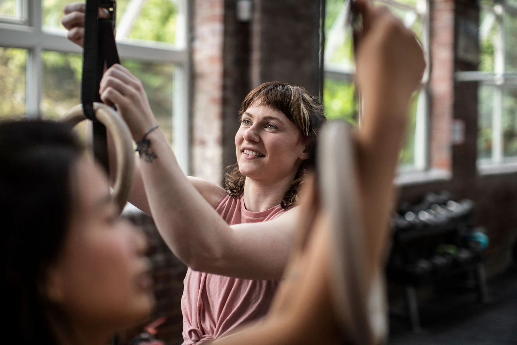 En kvinna instruerar en person i ett gym