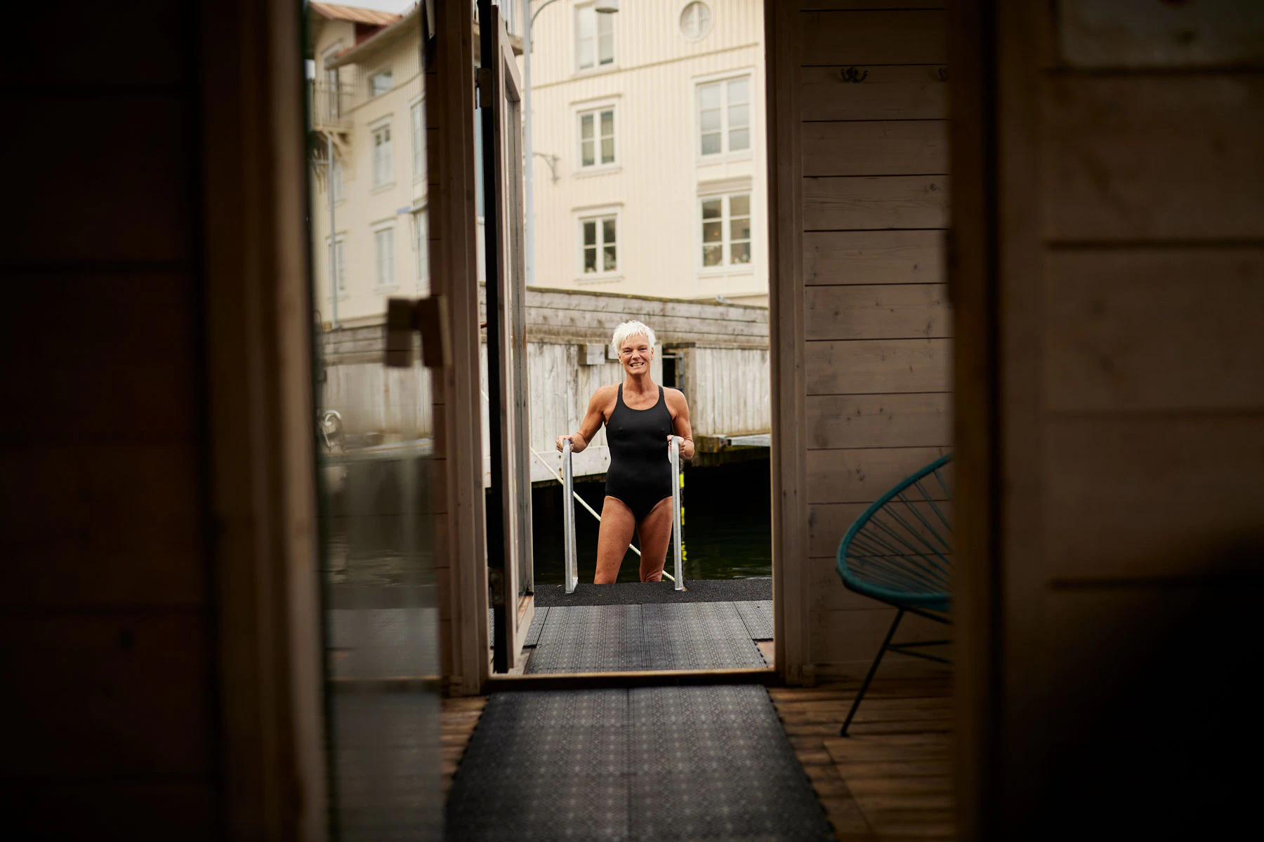 A woman exiting water to get in to a sauna