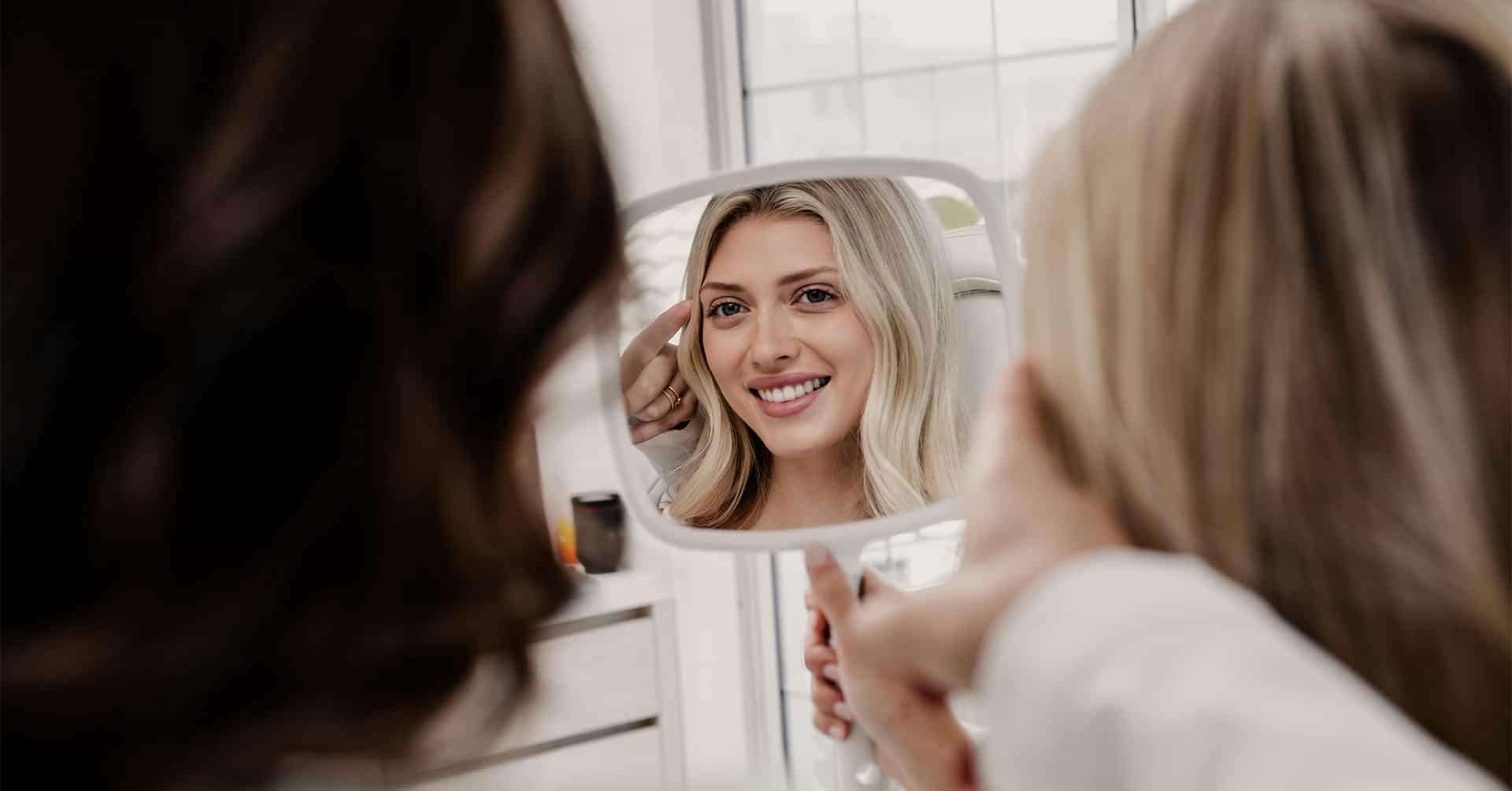 A woman looking at her face in a mirror