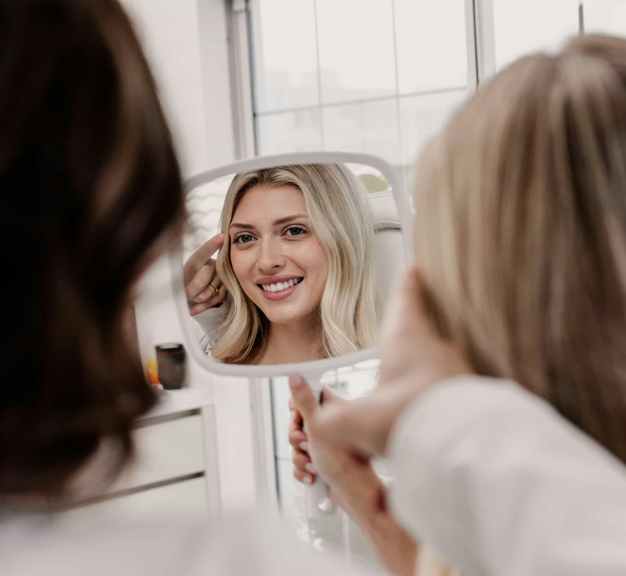 A woman looking at her face in a mirror