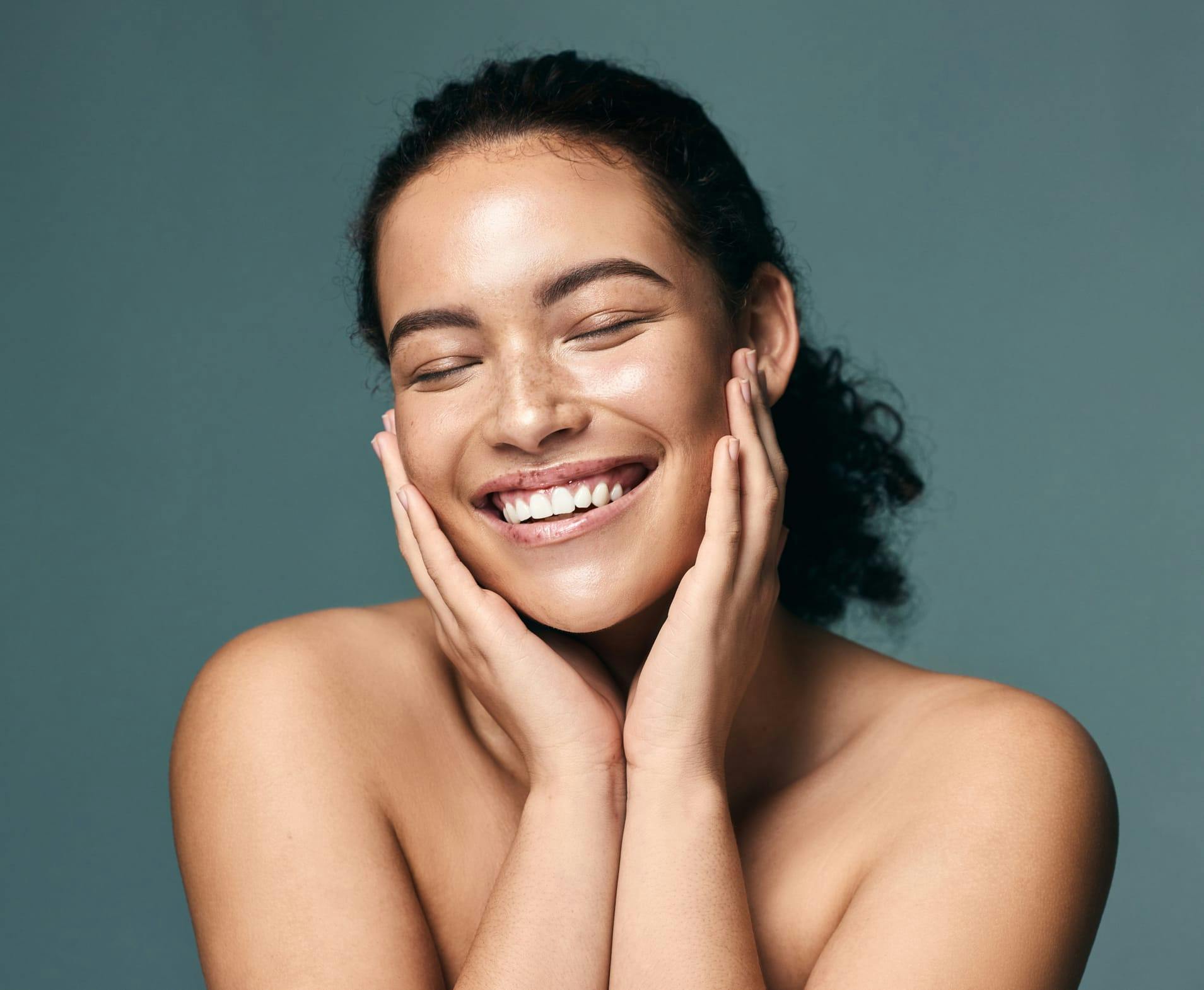 Woman smiling while holding her cheeks