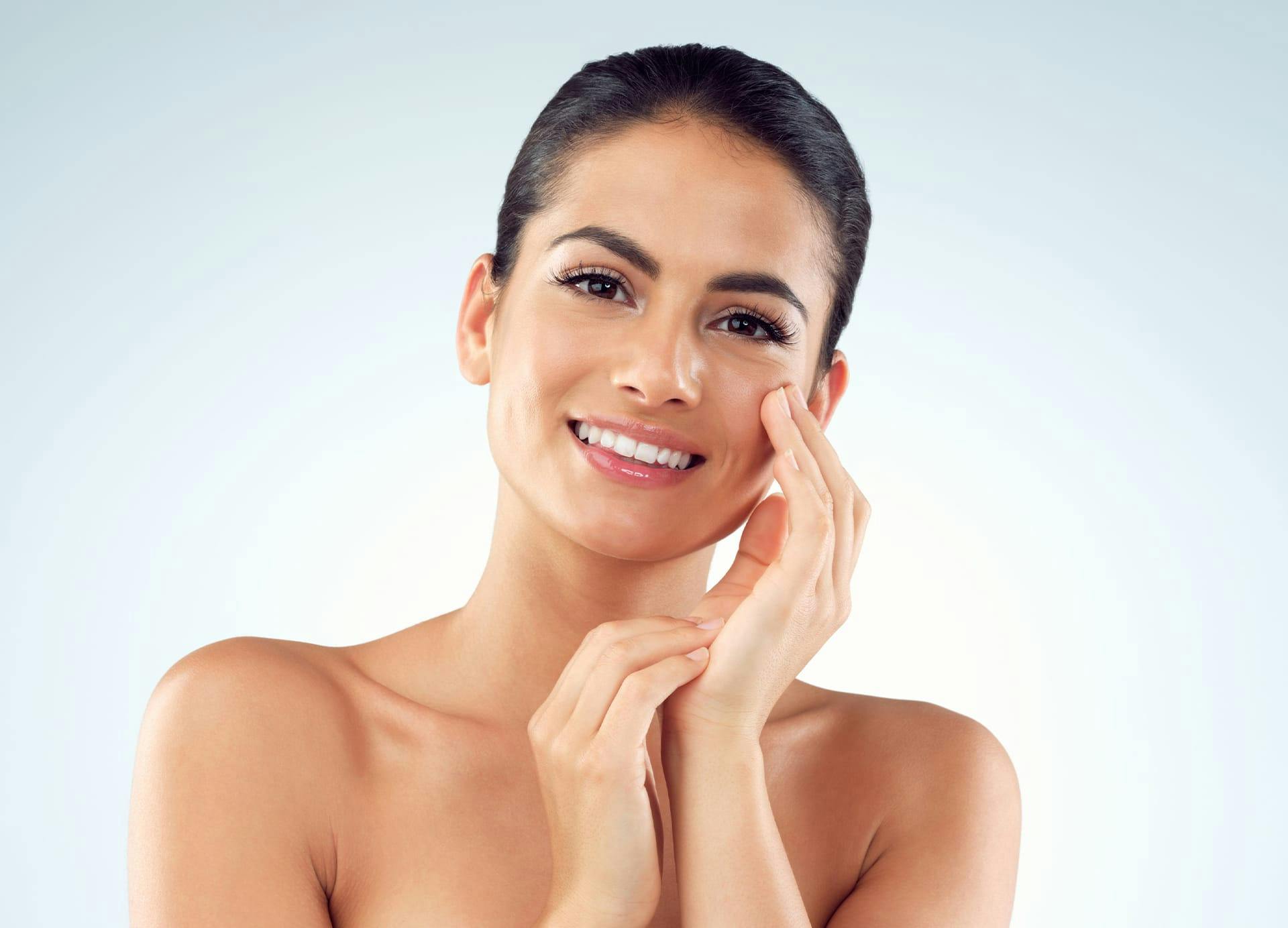 Wman smiling and touching her cheek