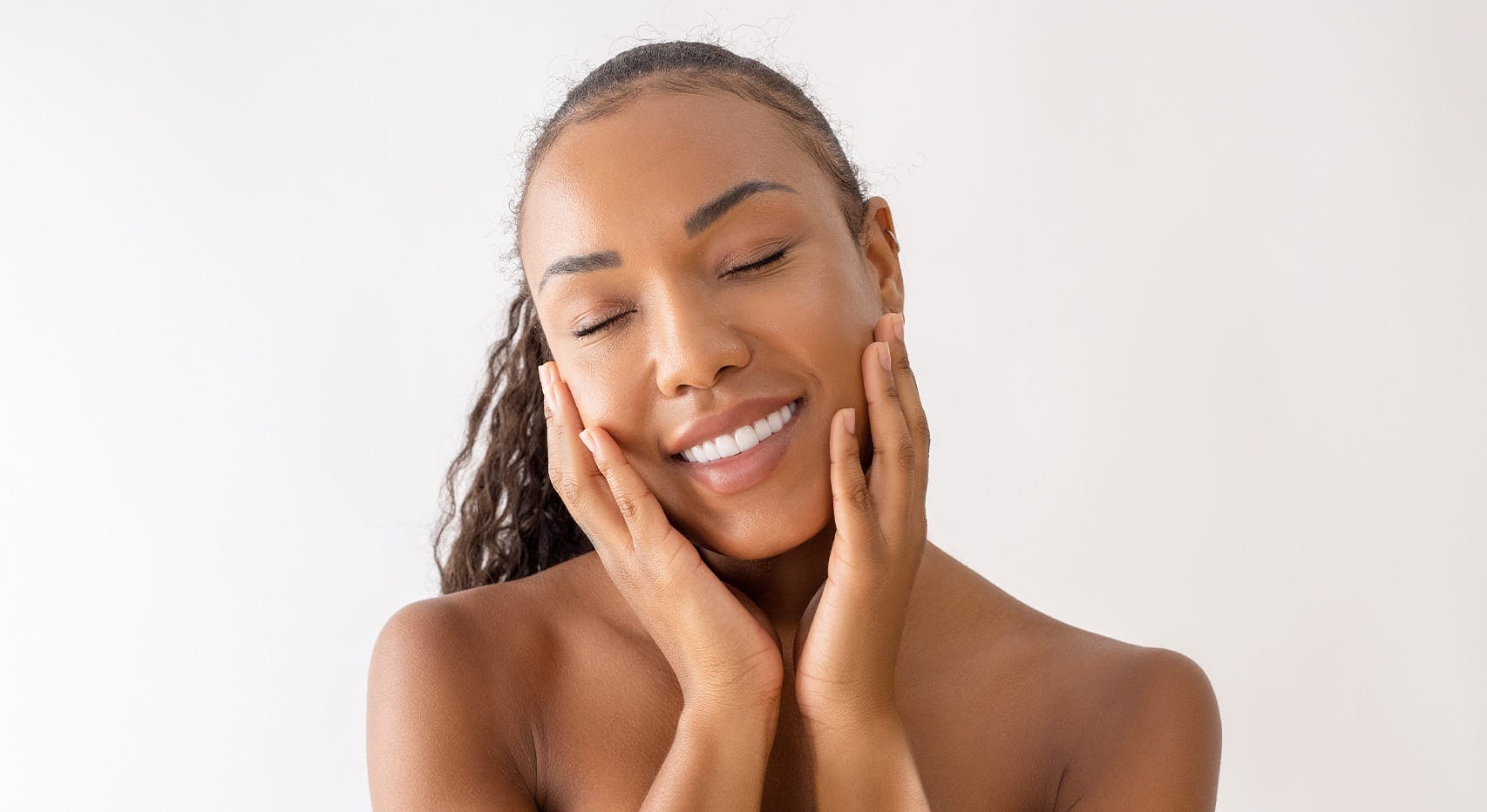 Woman smiling and holding cheeks