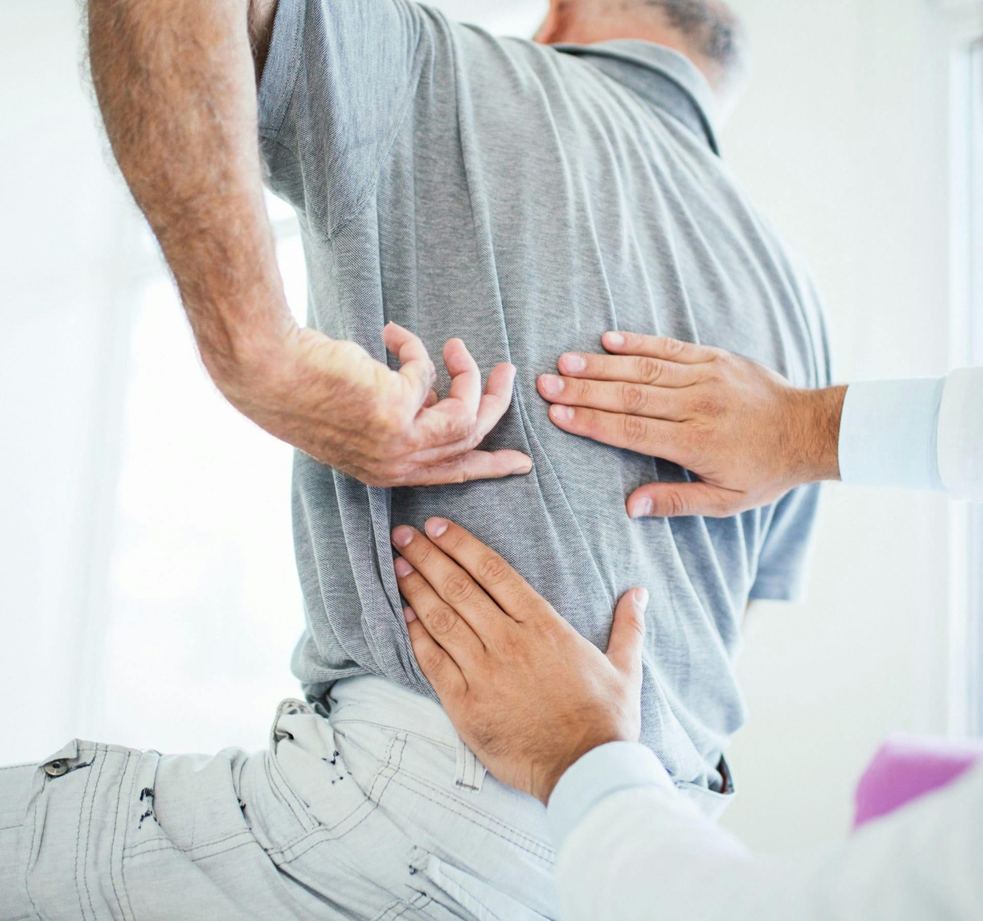 doctor feeling a patient's back