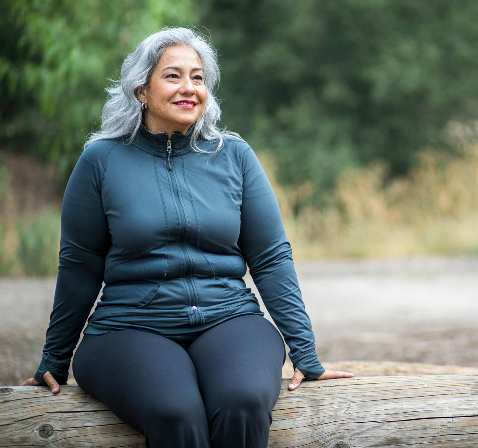 older woman sitting on a log