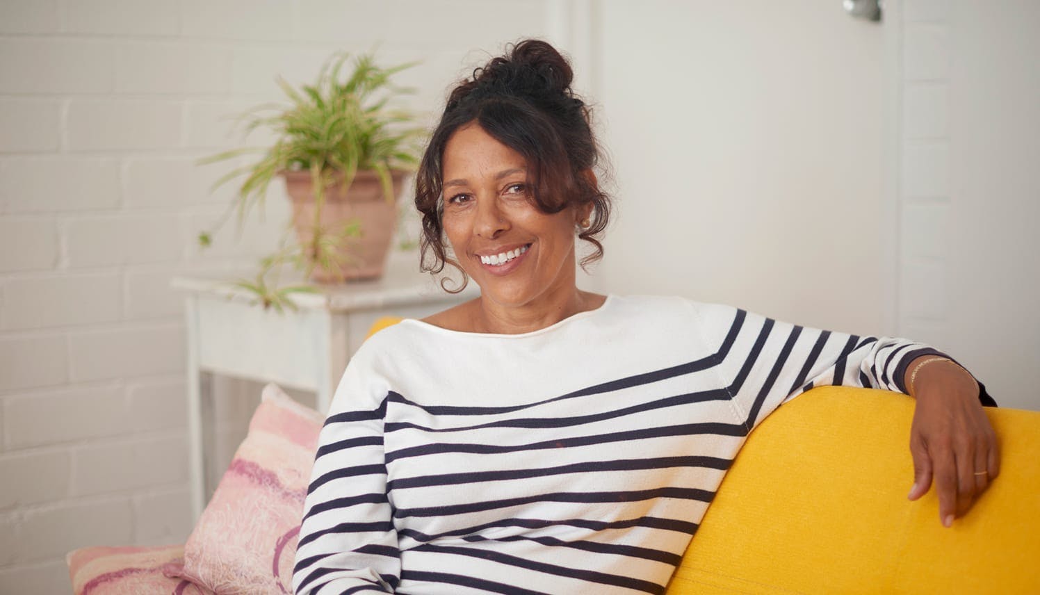 older woman sitting on a yellow couch