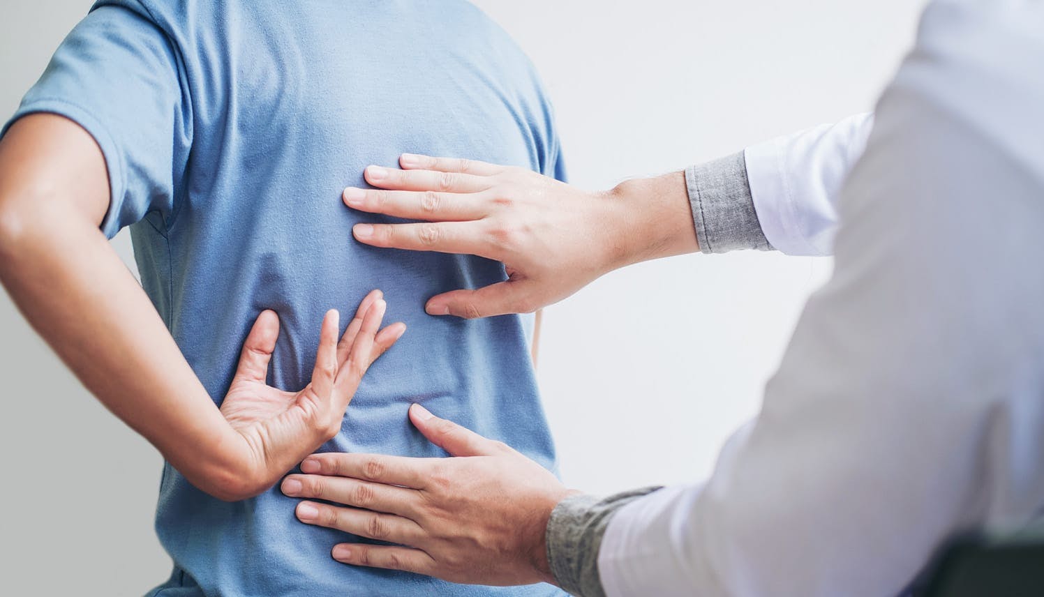 doctor feeling a patient's back