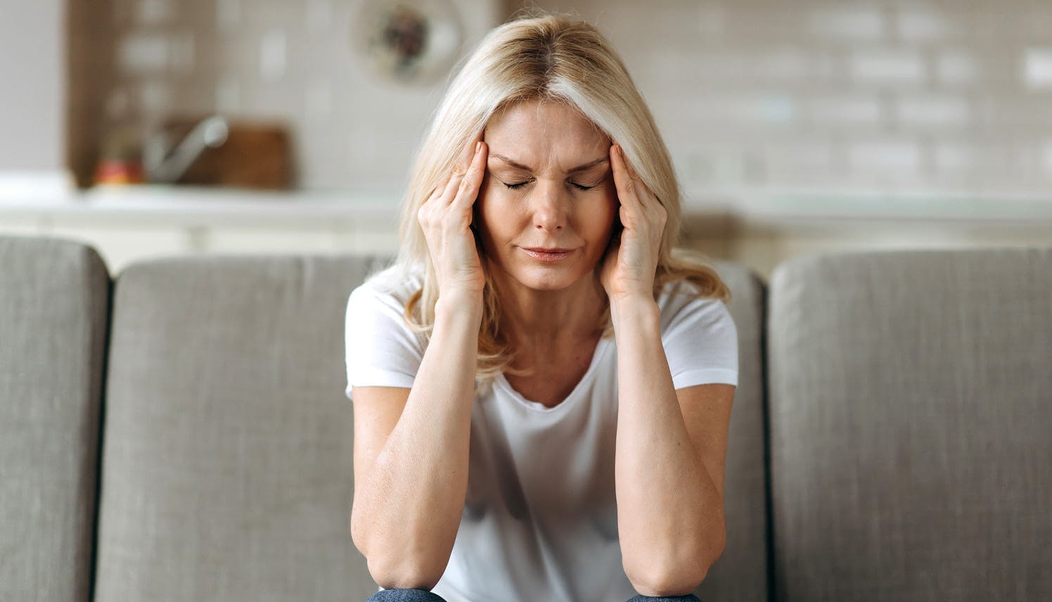 woman holding her head in pain