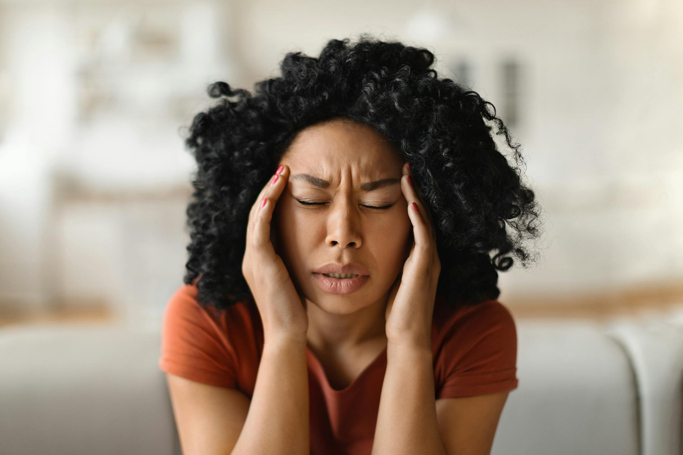 Woman rubbing her temples with painful look on her face