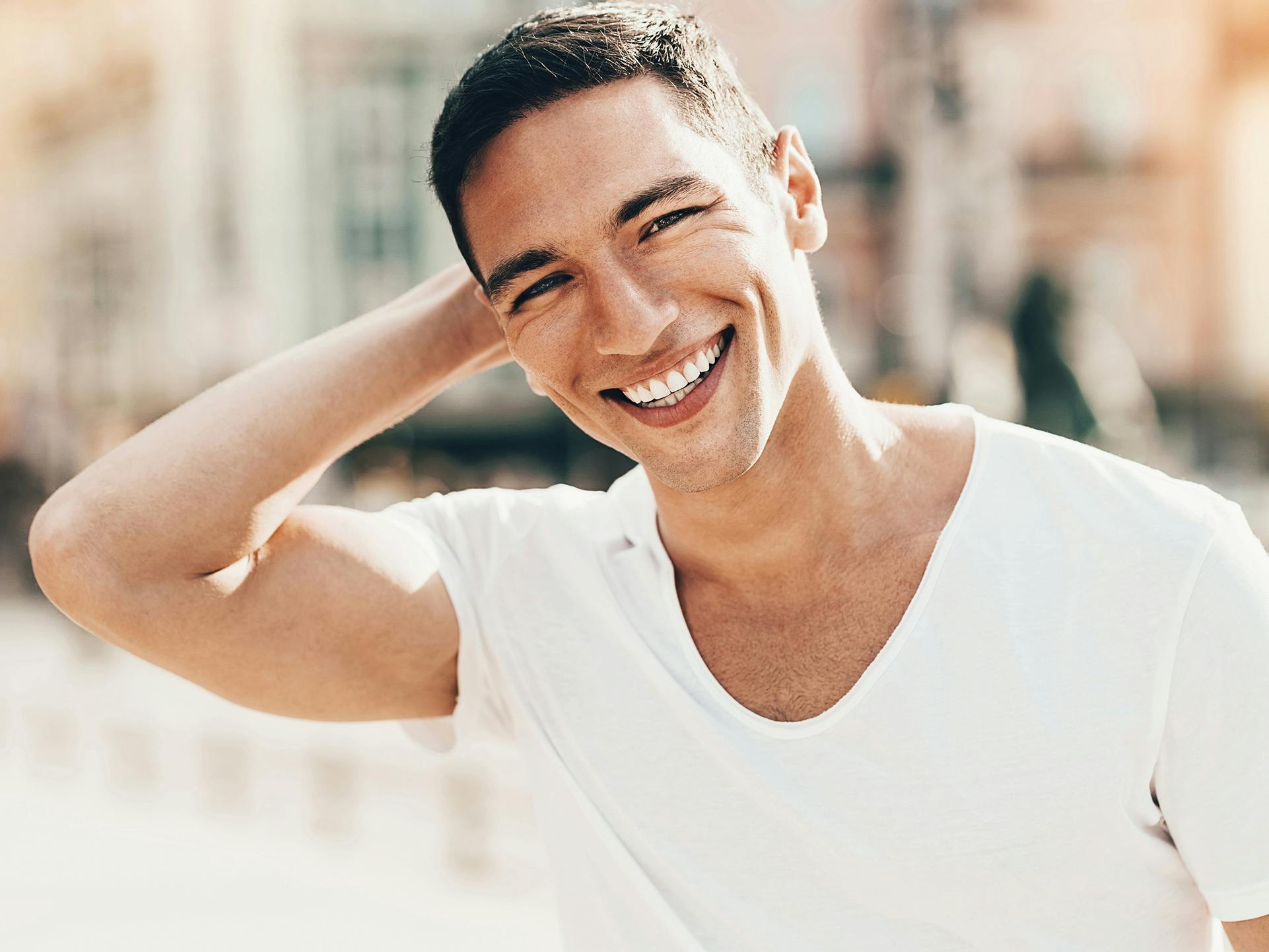 man smiling with arm behind his head