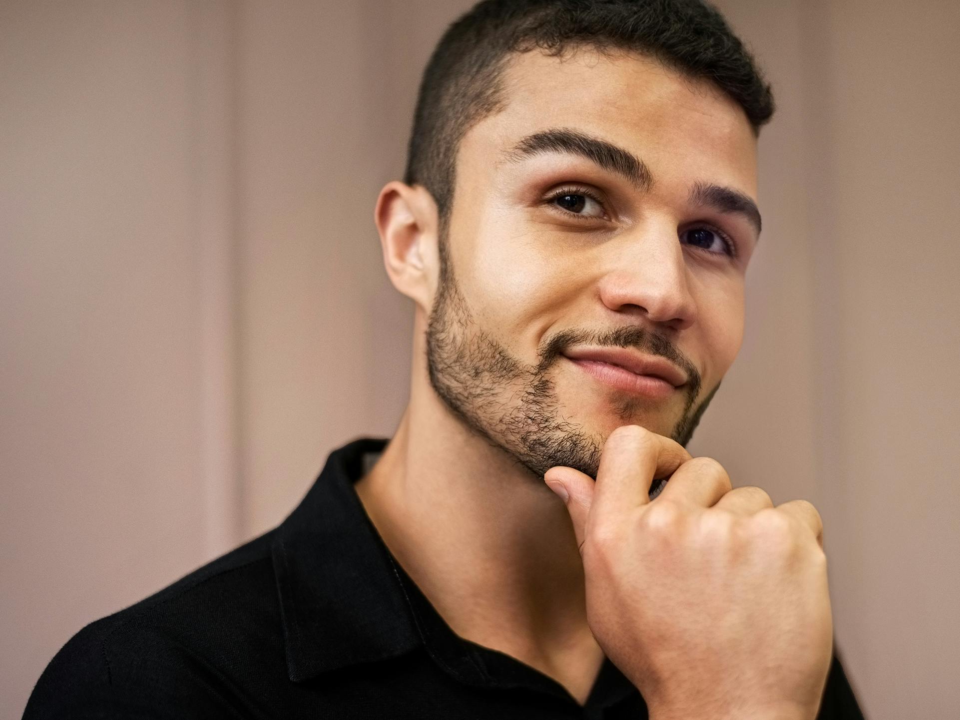 man smirking with hand on chin