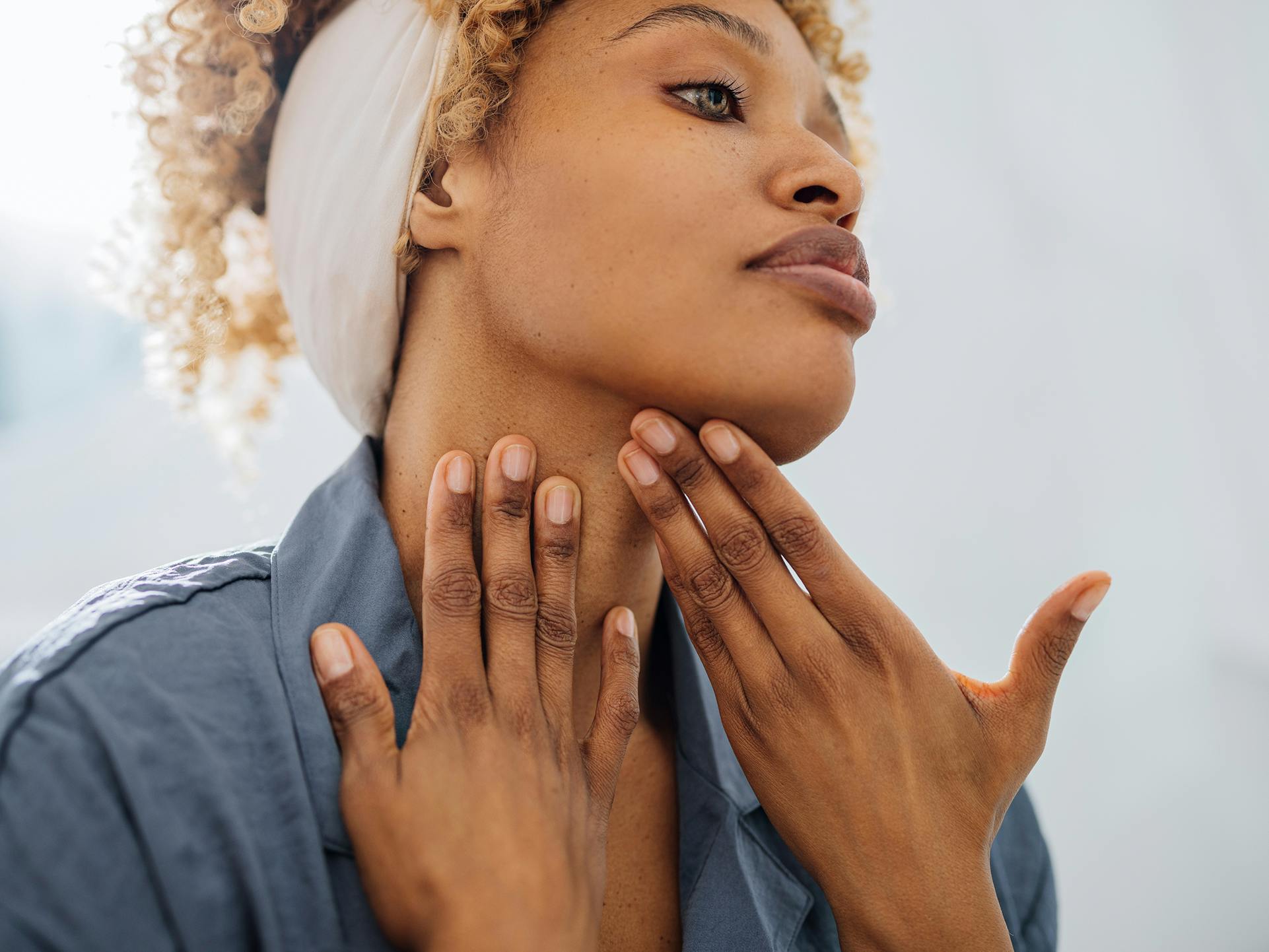 lady looking at her neck in mirror