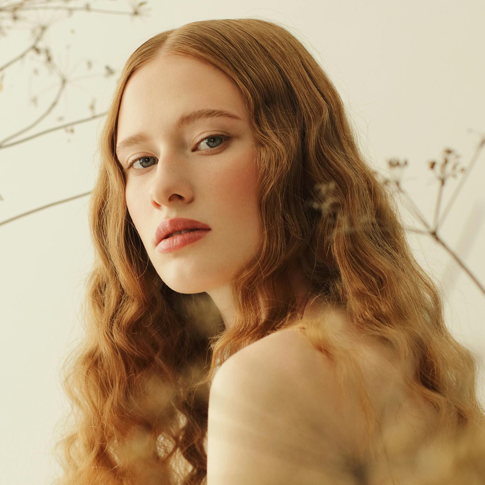 lady with wavy hair looking over shoulder