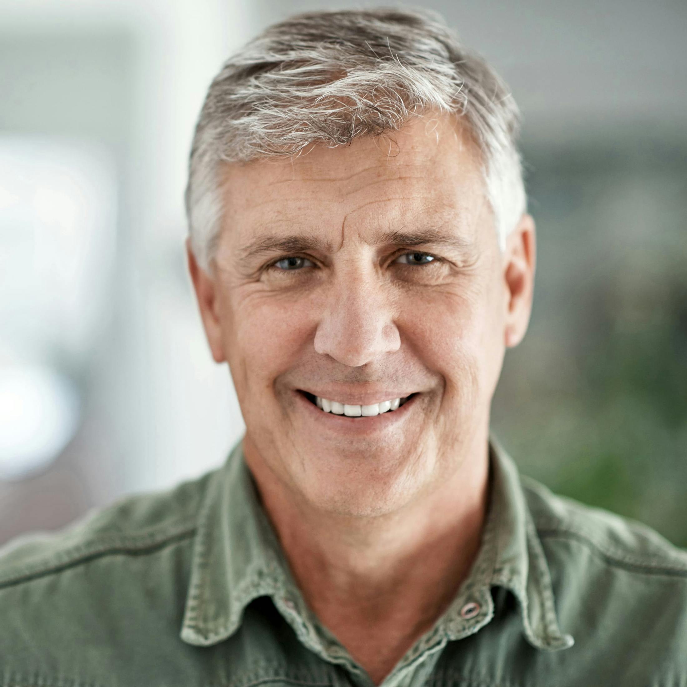 man with grey hair and green shirt