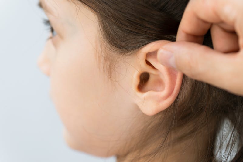 child's ear being inspected for ear surgery