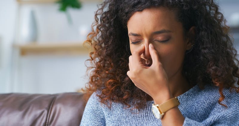 woman clasping her nose in pain