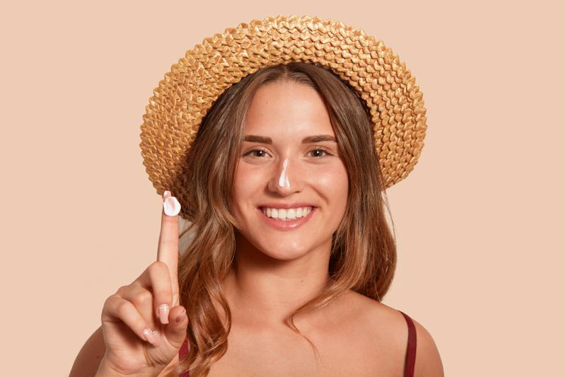 woman applying sunscreeen to her face