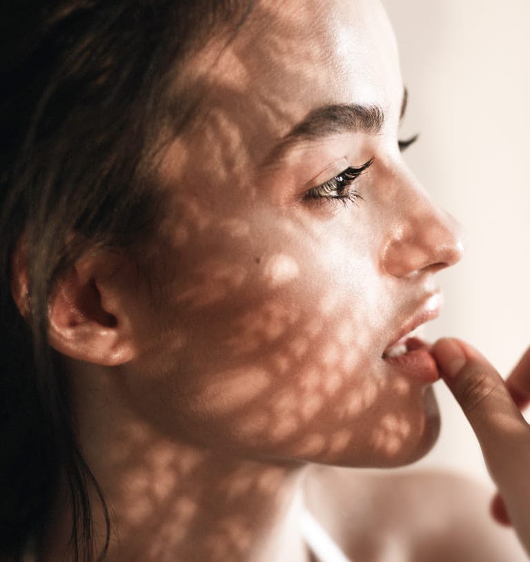 Woman looking off in the distance with her thumb on her bottom lip