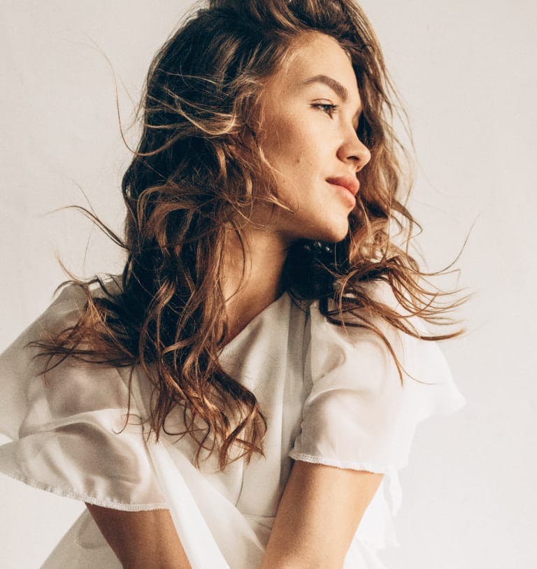 Woman with wind blown hair looking off to her left