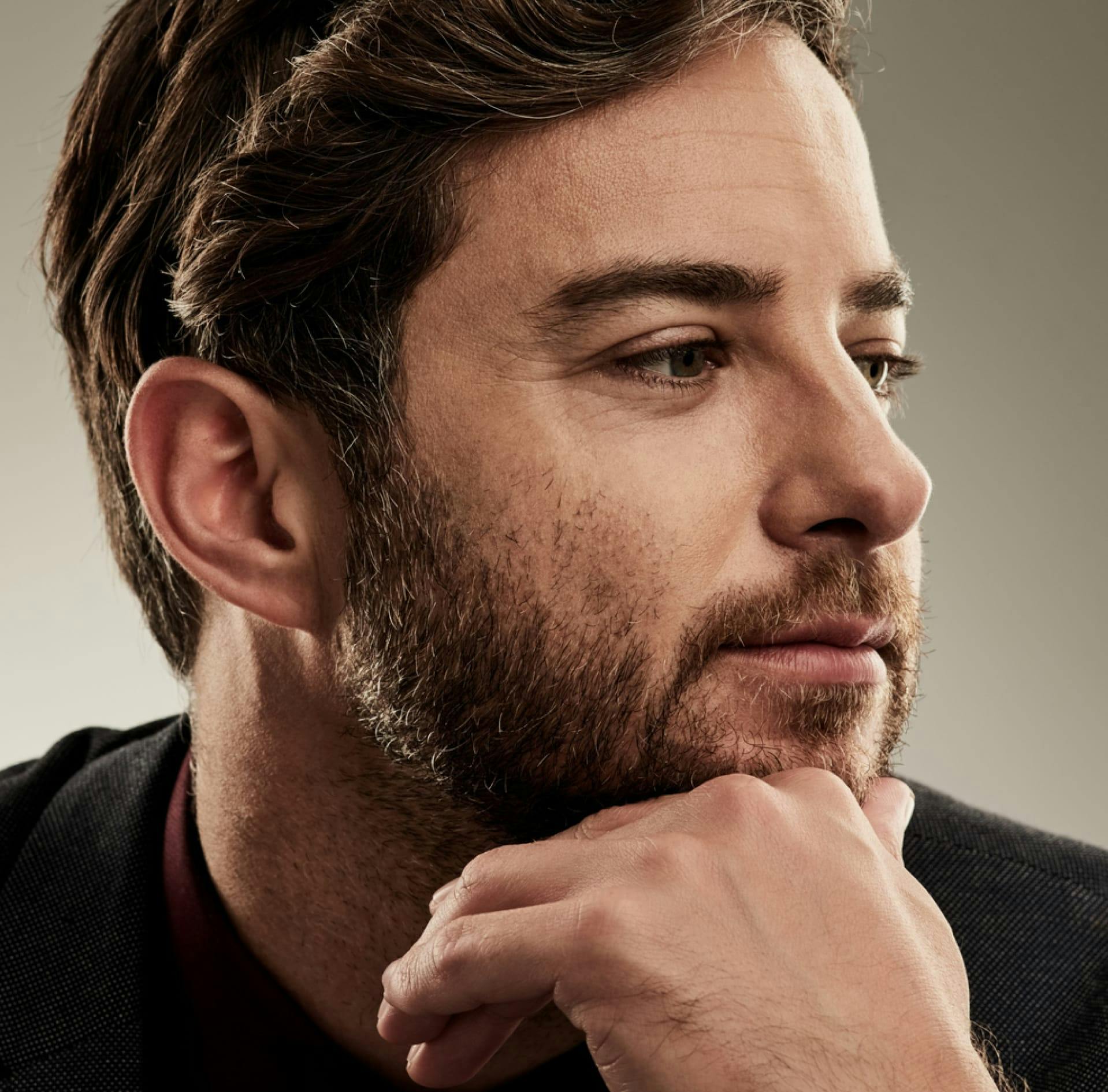 Man looking to the right with his hand on his chin