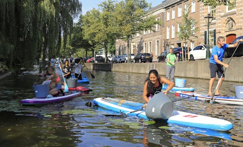 Plastic zwerfafval uit de Leidse grachten vissen met leerlingen van de Lucan van Leyden school