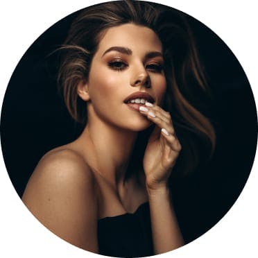 Woman with wavy hair and her fingers to her lips