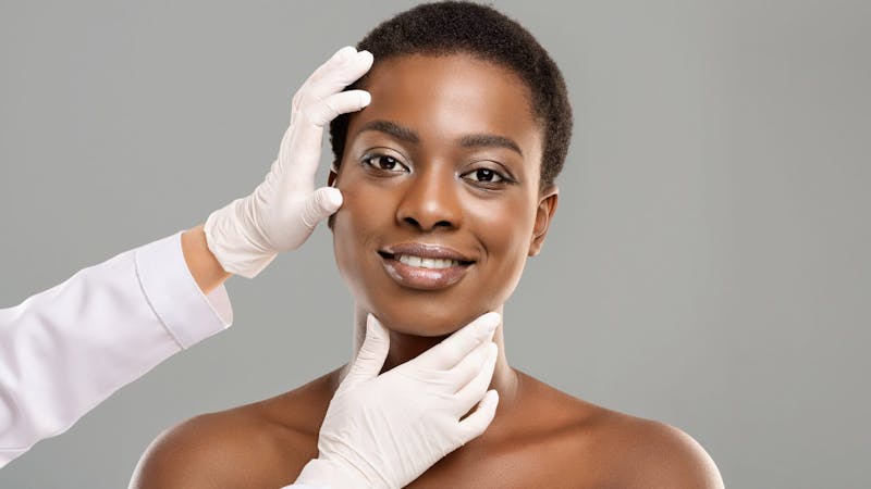 woman having her face examined by a plastic surgeon