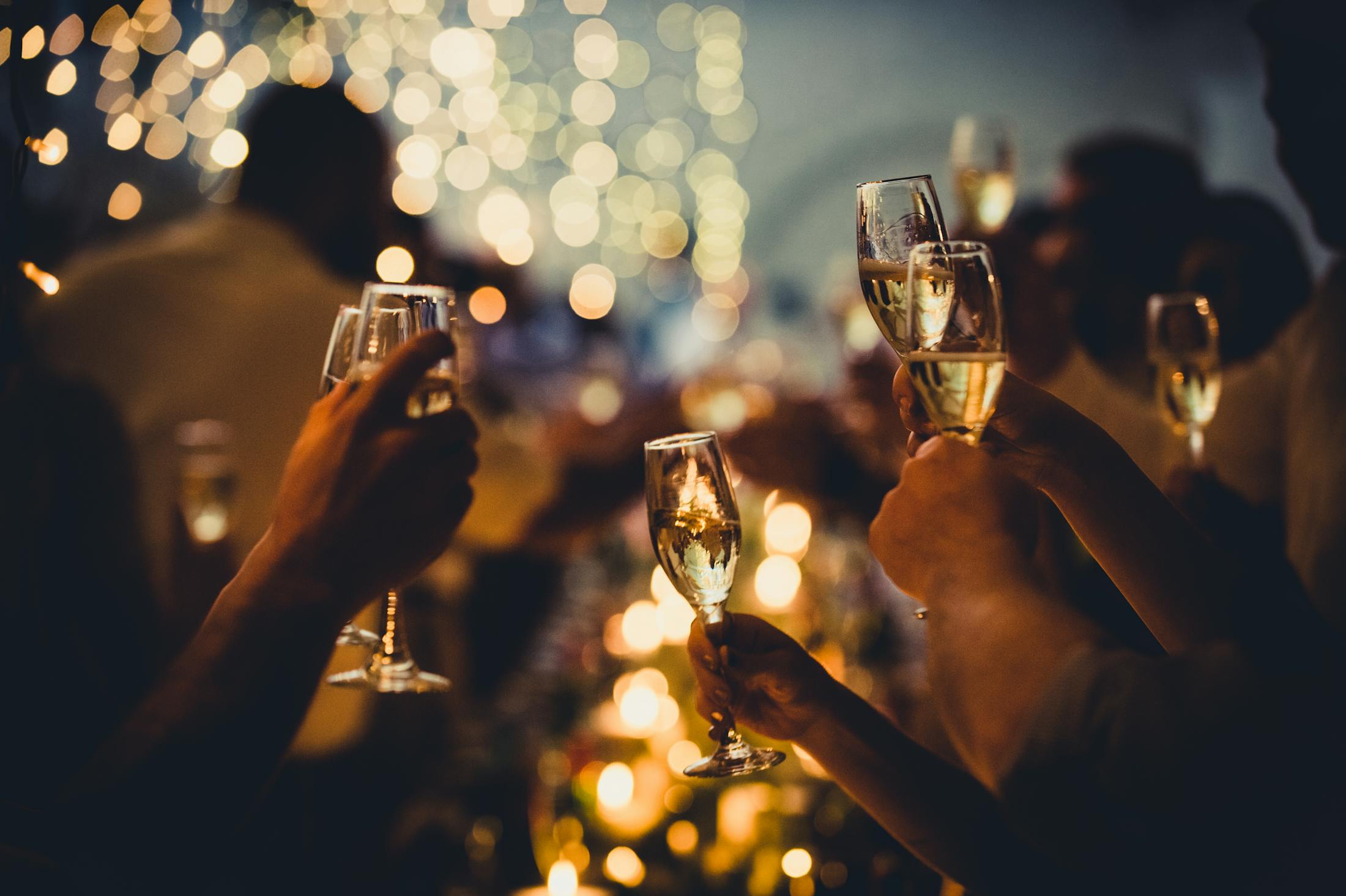 Wine glasses being raised in a party setting