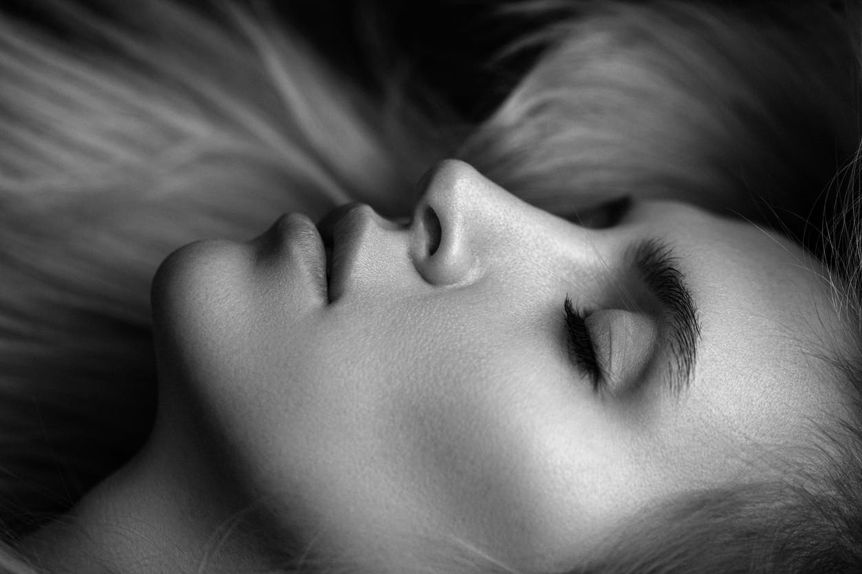 Black and White photo of woman lying down. Her eyes are clsoed and she has a perfect profile. Her nose is straight and is used to show the potential results of a rhinoplasty with Dr. Torkian.