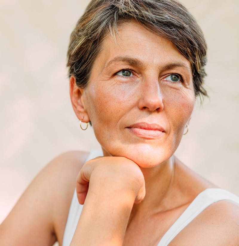 Female staring off the distance with her hand on her chin