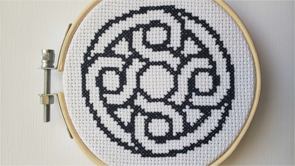 Cross stitch of the Mercury logomark