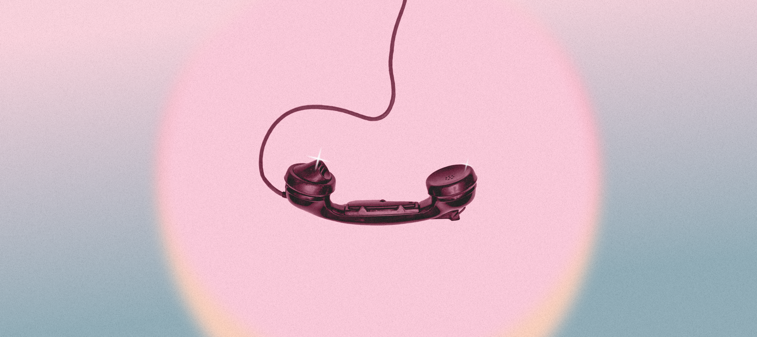 A black analog telephone in a pink and blue spotlight