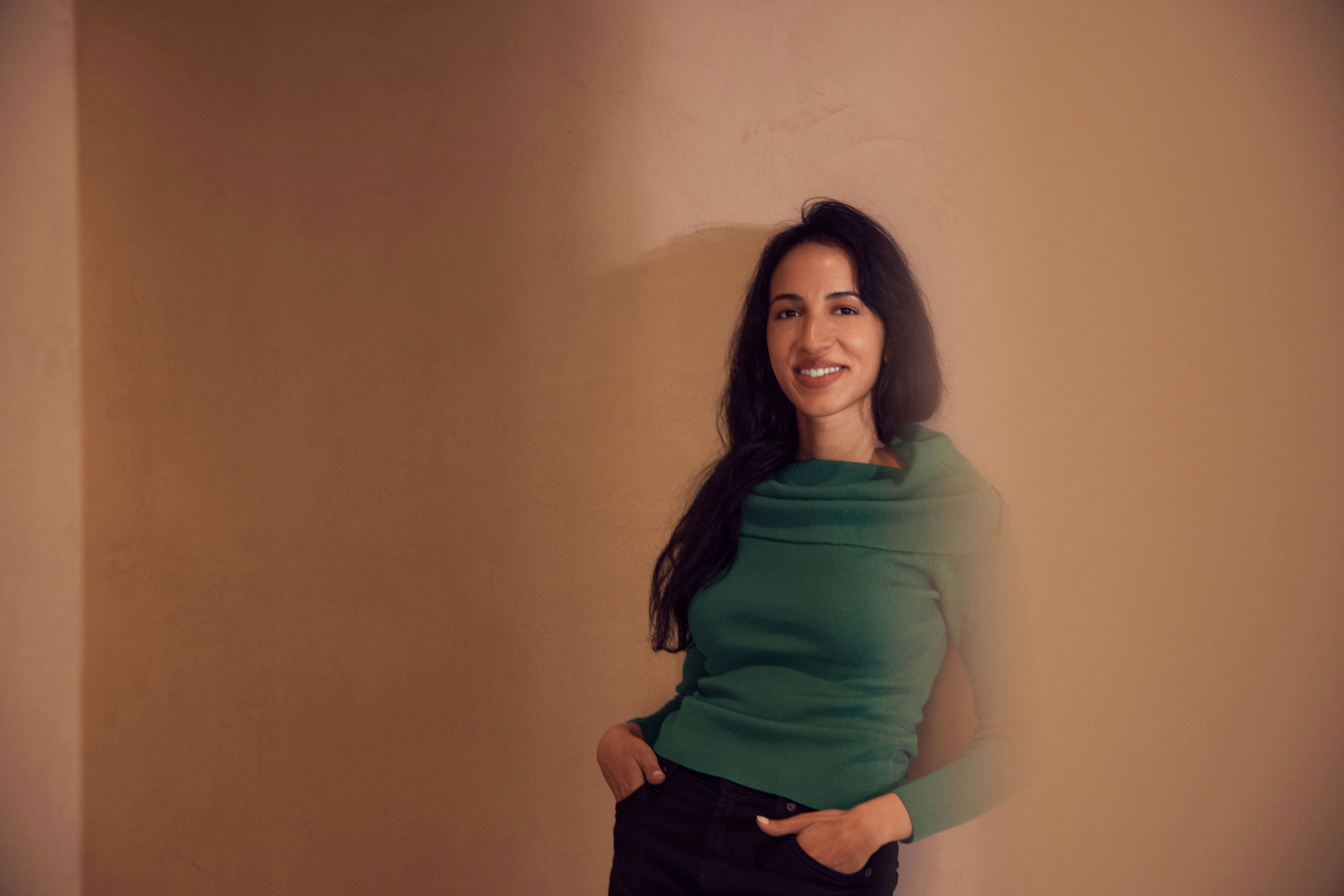 Photograph by Derek Yarra of Noor Siddiqui in a green sweater with her hands in pocket | Meridian by Mercury Photograph by Derek Yarra of Noor Siddiqui in a green sweater with her hands in pocket | Meridian by Mercury