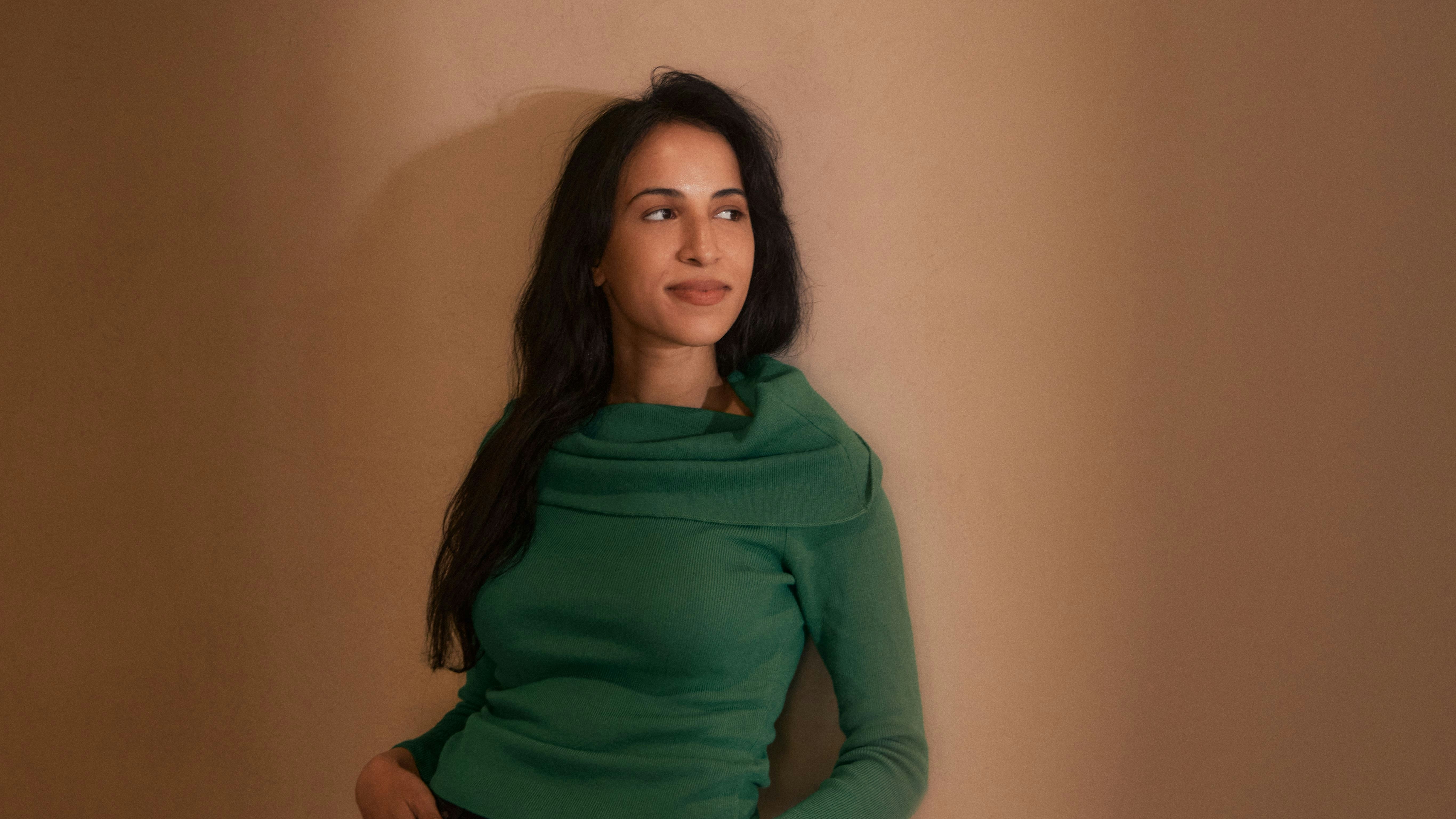 Photography by Derek Yarra of Noor Siddiqui standing against a wall | Meridian by Mercury Photography by Derek Yarra of Noor Siddiqui standing against a wall | Meridian by Mercury