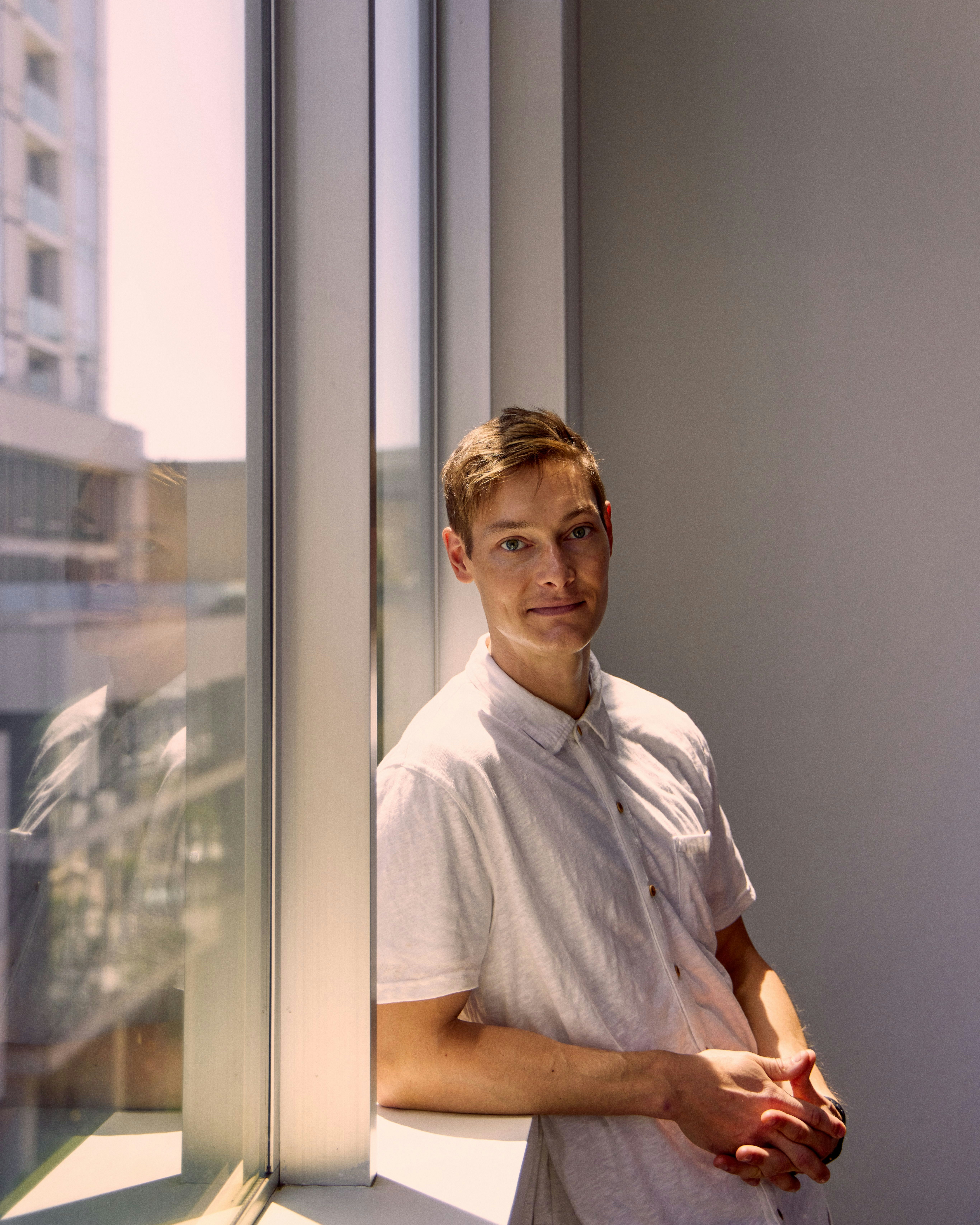 Photograph of Ryan Hoover leaning against the window of his home | Derek Yarra for Meridian Photograph of Ryan Hoover leaning against the window of his home | Derek Yarra for Meridian