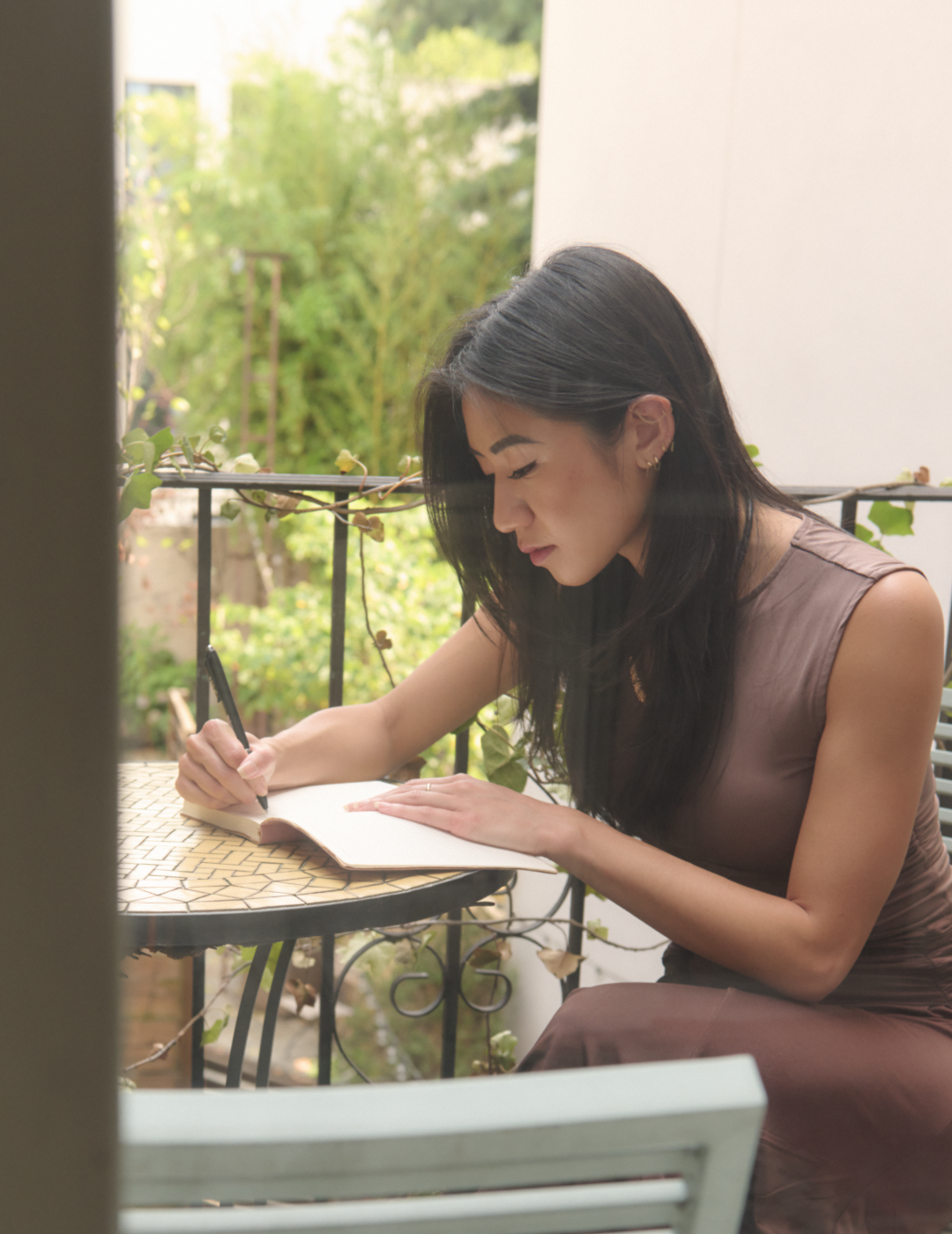 Pham on her patio writing on a notepad