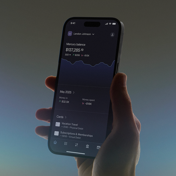 A hand holds a smartphone showing Mercury Personal with balance and recent activity.
