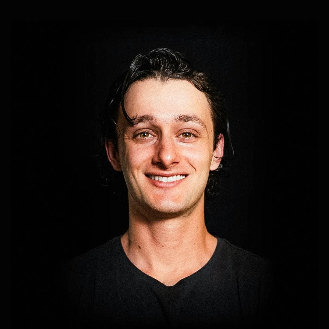 Smiling man wearing black T-shirt looks directly at the camera.